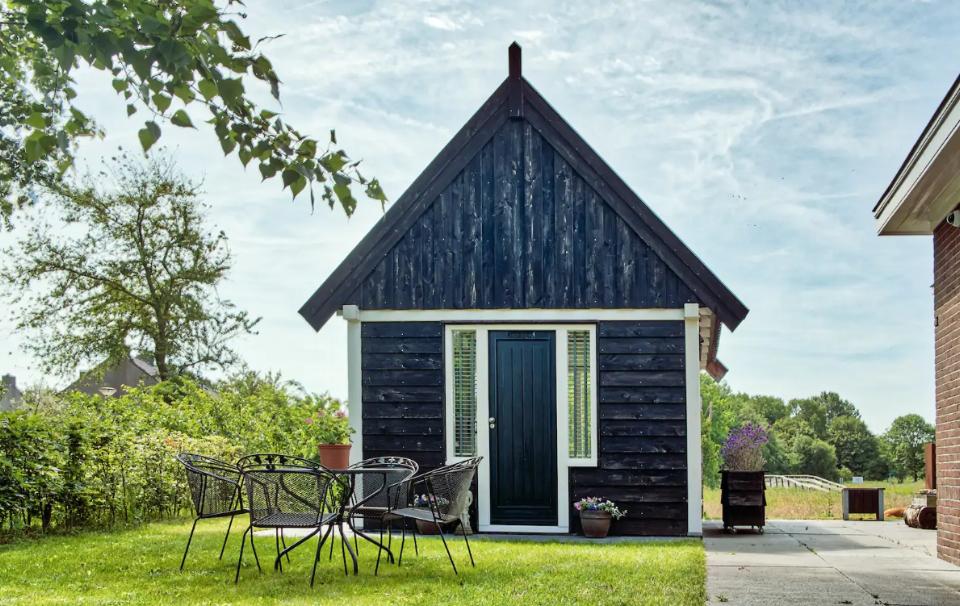 klein houten huisje met stoelen op het gras